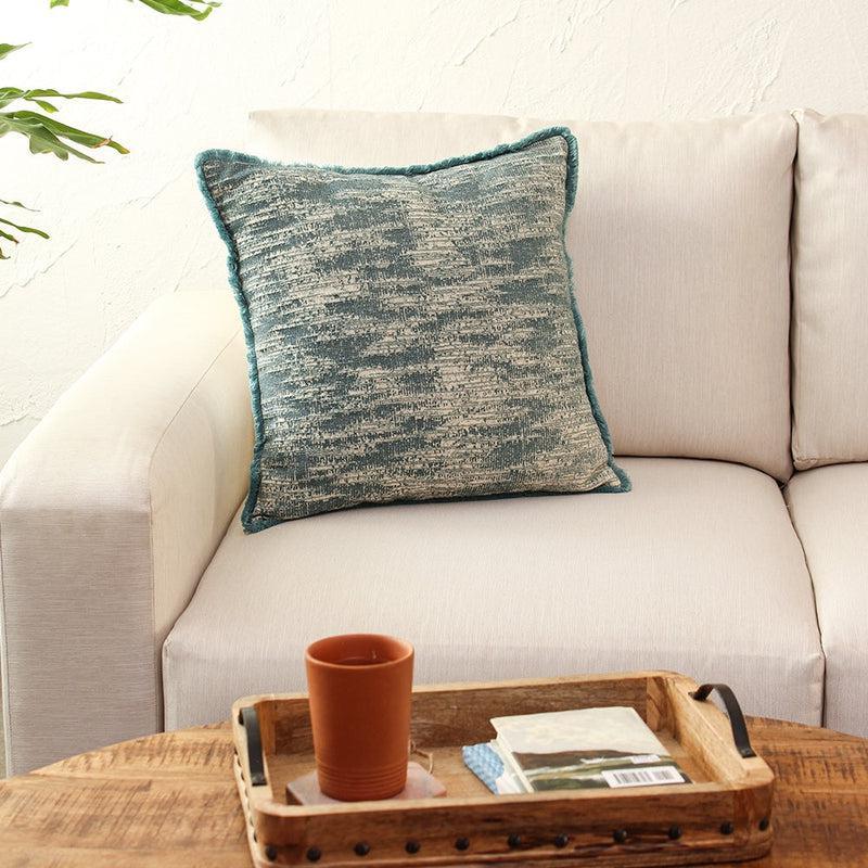 The Cobalt Nights Cushion, a square accent pillow with distressed pattern on a sofa you can buy online at Sukham Home, a sustainable furniture, kitchen & dining and home decor store in Kolkata, India.