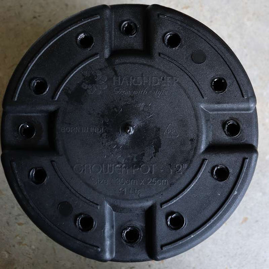 Bottom of the 12 inch black nursery pot and gardening tools you can buy online at Sukham Home, a sustainable furniture, gardening and home decor store in Kolkata, India