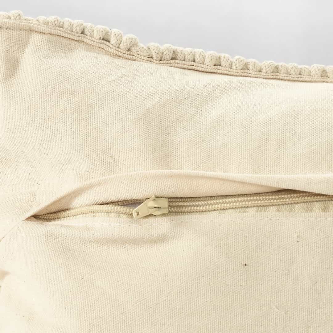 Close up of the zip of the Beige White Macrame Cushion with Fringes, a square accent pillow you can buy online at Sukham Home, a sustainable furniture, kitchen & dining and home decor store in Kolkata, India