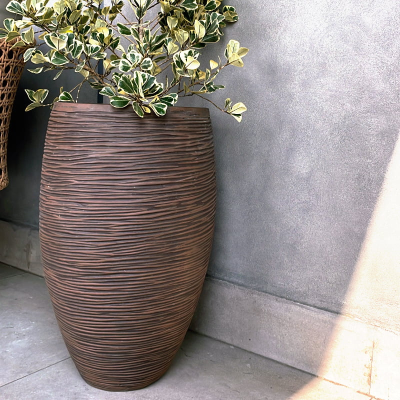 On a rooftop terrace, the Dark Brown Dual Tone Wood Rib High, a round tall textured luxury planter made from FRP you can buy online at Sukham Home, a sustainable furniture, gardening and home decor store in Kolkata, India