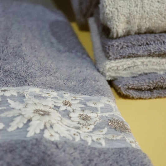 Close up of the hand towel and face towels from the Grey & Beige Silly-Cuddly, a set of 8 floral embroidered towels you can buy online at Sukham Home, a sustainable furniture, kitchen & dining and home decor store in Kolkata, India