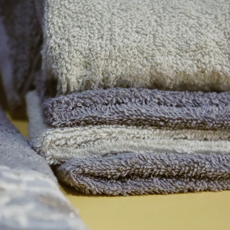 Four face towels from the Grey & Beige Silly-Cuddly, a set of 8 floral embroidered towels you can buy online at Sukham Home, a sustainable furniture, kitchen & dining and home decor store in Kolkata, India