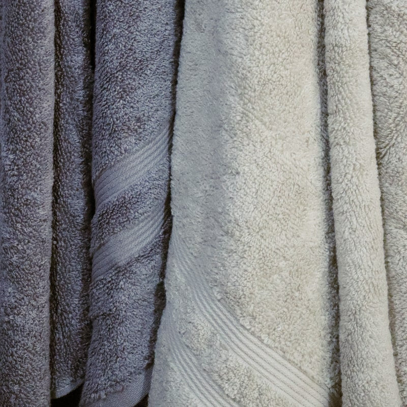 Close up of the bath towels from the Grey & Beige Silly-Cuddly, a set of 8 floral embroidered towels you can buy online at Sukham Home, a sustainable furniture, kitchen & dining and home decor store in Kolkata, India