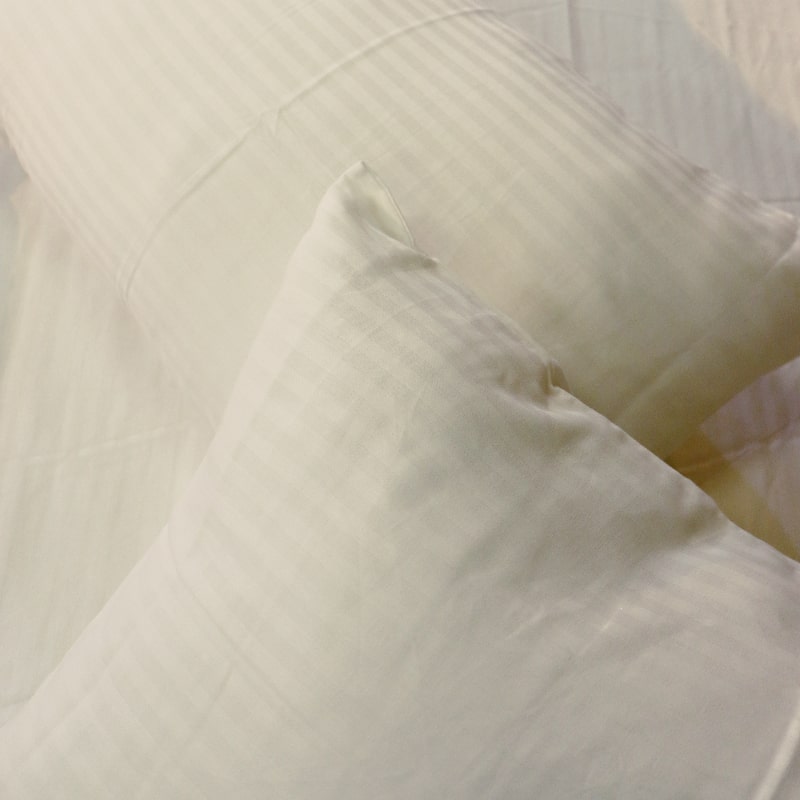 Close up of the texture and fabric of the White Sateen Striped Bedsheet, a king and queen size cotton bedsheet you can buy online at Sukham Home, a sustainable furniture, gardening and home decor store in Kolkata, India