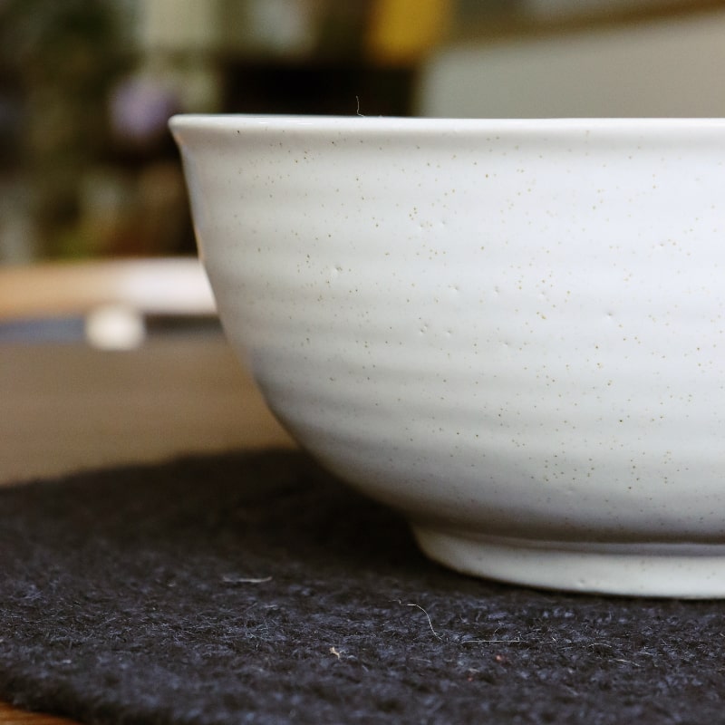 Close up of the ribbed texture of the Ivory Ganga Serving Bowl, a white and 24-karat gold ceramic serving big bowl you can buy online at Sukham Home, a sustainable furniture, gardening and home decor store in Kolkata, India