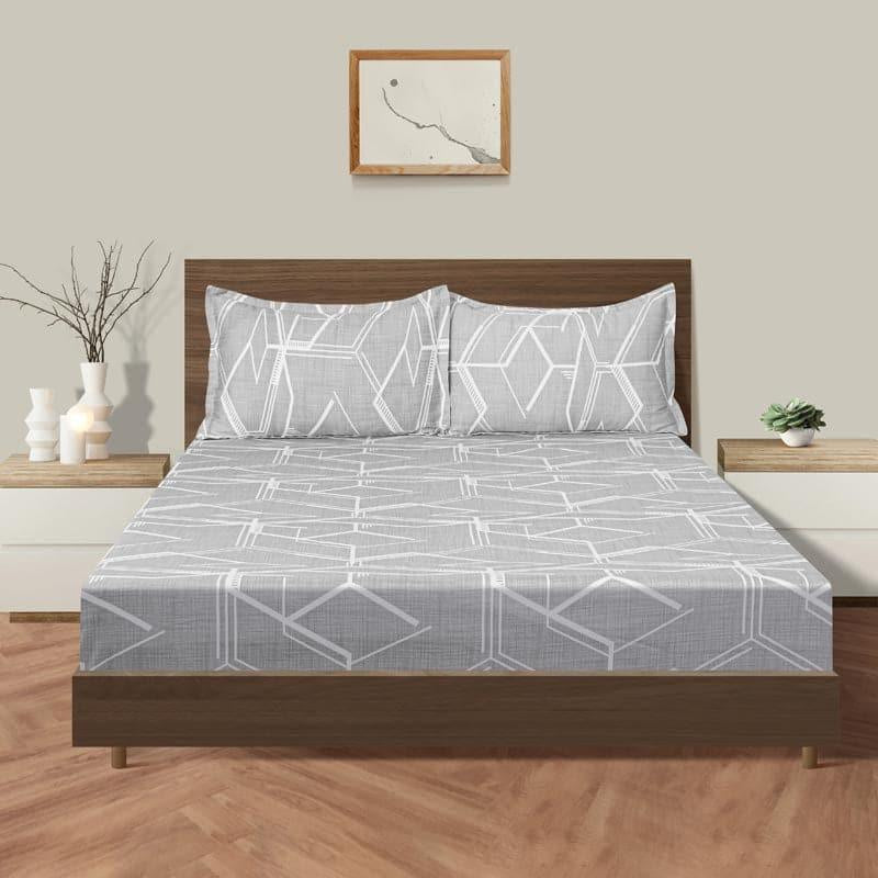 Placed on a bed, the Architectural Dreams, a printed grey geometrical king size bedsheet you can buy online at Sukham Home, a sustainable furniture, gardening and home decor store in Kolkata, India