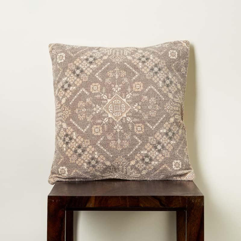 A piece of the Badami Cushion, a square accent pillow with ethnic prints on a stool you can buy online at Sukham Home, a sustainable furniture, kitchen & dining and home decor store in Kolkata, India.