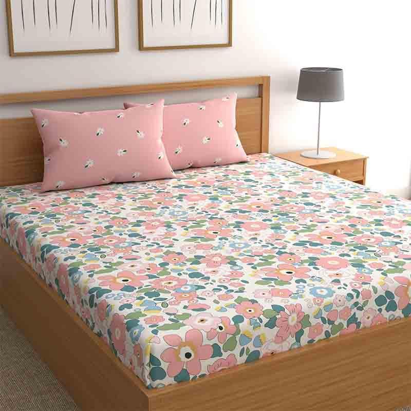 Laid out on a bed, the Blushing Blooms, a printed pink floral king size bedsheet you can buy online at Sukham Home, a sustainable furniture, gardening and home decor store in Kolkata, India