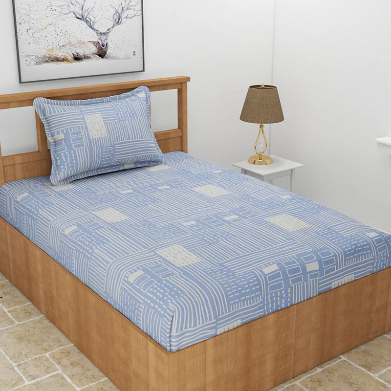 Laid out on a bed, the Cerulean Shores, a printed blue geometric queen size bedsheet you can buy online at Sukham Home, a sustainable furniture, gardening and home decor store in Kolkata, India