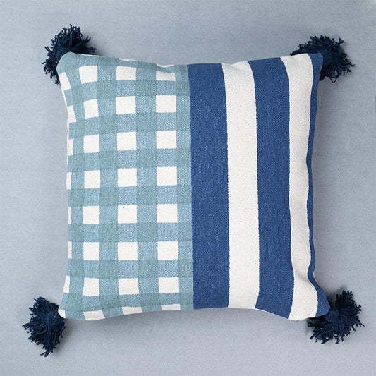 Against a light background the Checks and Stripes Cushion, a square accent pillow with tassels and modern prints you can buy online at Sukham Home, a sustainable furniture, kitchen & dining and home decor store in Kolkata, India.