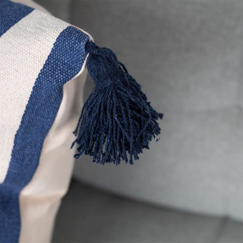 Corner closeup of the tassel of the Checks and Stripes Cushion, a square accent pillow with tassels and modern prints you can buy online at Sukham Home, a sustainable furniture, kitchen & dining and home decor store in Kolkata, India.