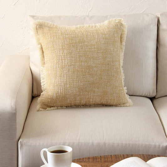 The Legally Blonde Cushion, a square accent pillow with warm distressed pattern put on a sofa you can buy online at Sukham Home, a sustainable furniture, kitchen & dining and home decor store in Kolkata, India.