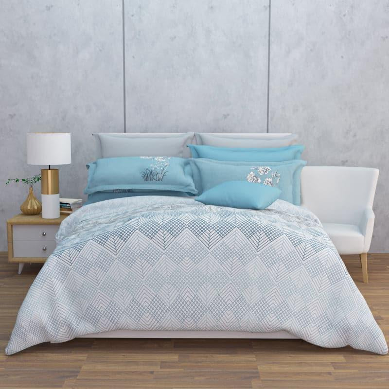 Laid out on a bed from the front view, the Hazy Blues, a printed blue geometric super king size bedsheet you can buy online at Sukham Home, a sustainable furniture, gardening and home decor store in Kolkata, India