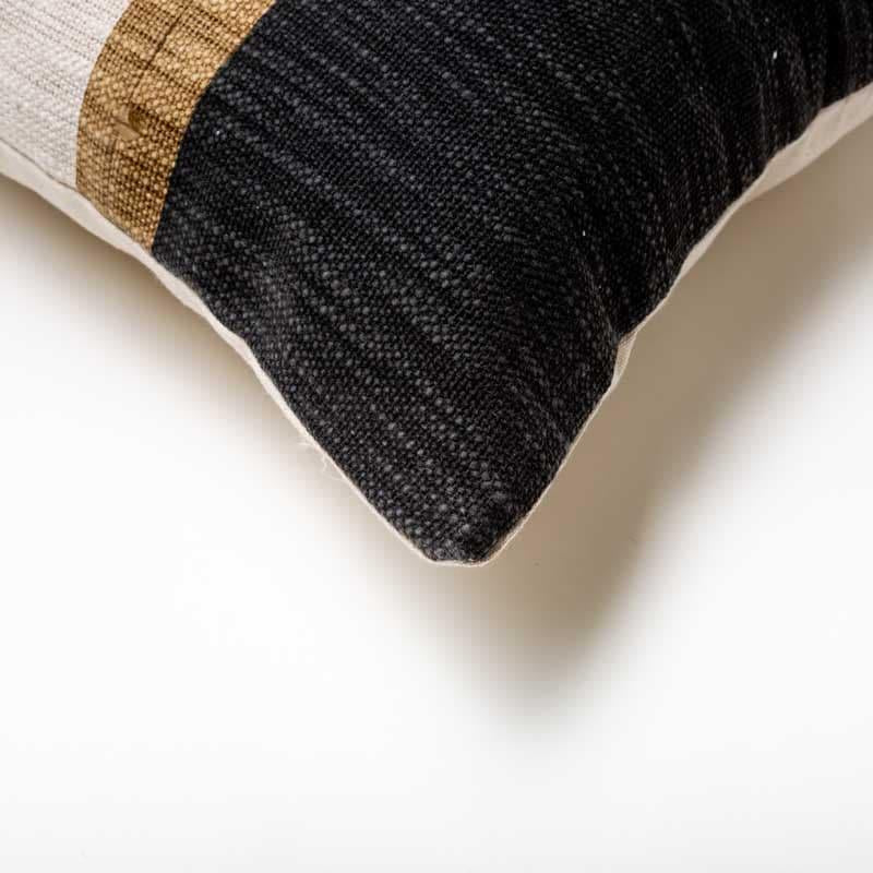 Corner of the Inked in Charcoal Cushion, a square black and white and brown striped accent pillow you can buy online at Sukham Home, a sustainable furniture, kitchen & dining and home decor store in Kolkata, India