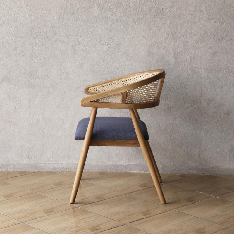 Pie Dining Chair with woven backrest and upholstered seat against a plain wall.