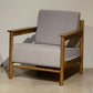 Front view of the Snug Armchair in Oak Natural using Buff White fabric, a wooden cushioned seat you can buy online at Sukham Home, a sustainable furniture and home decor store in Kolkata, India