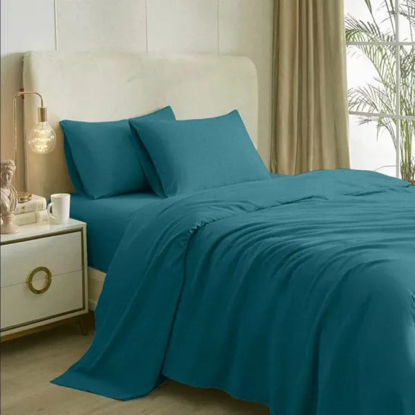 Spread on a bed, the Teal-Licious, a solid blue-green super king size bedsheet you can buy online at Sukham Home, a sustainable furniture, gardening and home decor store in Kolkata, India