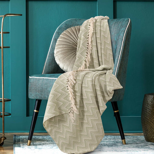 Placed on a chair, the Spruce Woven Throw, a green and white throw you can buy online at Sukham Home, a sustainable furniture, kitchen & dining and home decor store in Kolkata, India