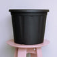 Distant view of the 16 inch black nursery pot and gardening tools you can buy online at Sukham Home, a sustainable furniture, gardening and home decor store in Kolkata, India