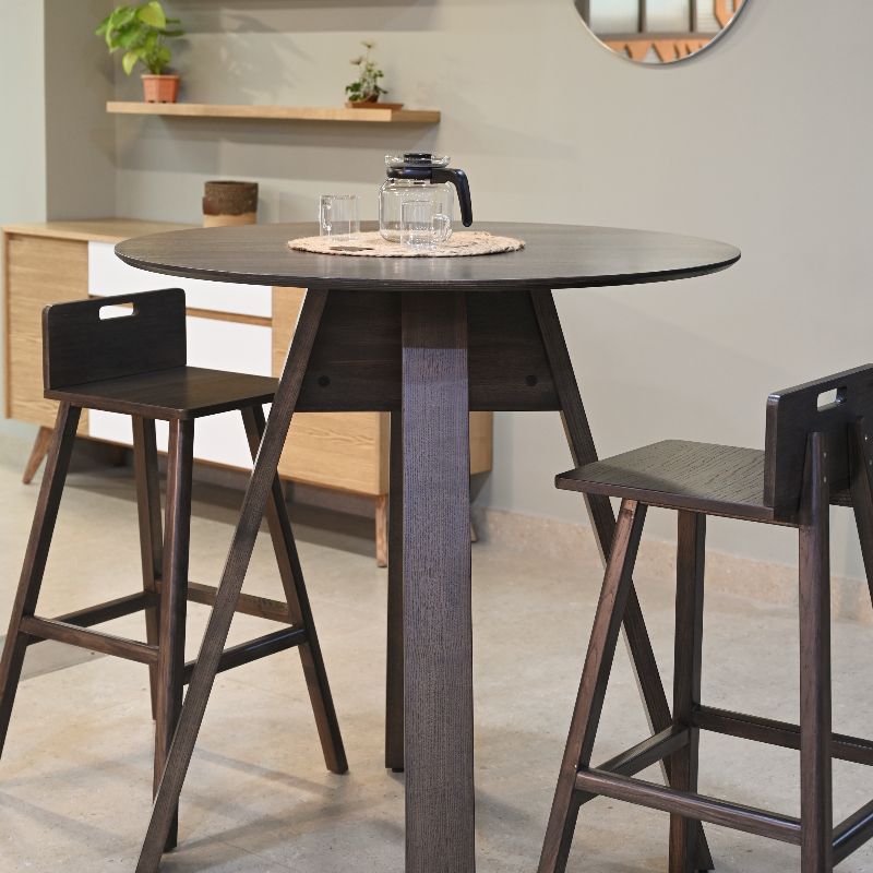 In Ash Grey, the Alpine, a wooden high round bar table you can buy online at Sukham Home, a sustainable furniture, kitchen & dining and home decor store in Kolkata, India