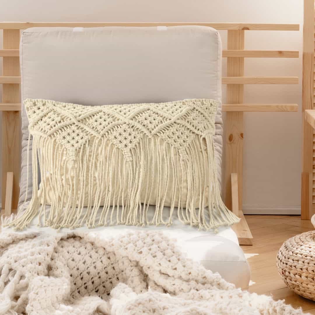 Arranged in a room, the Beige White Macrame Cushion with Fringes, a rectangle accent pillow you can buy online at Sukham Home, a sustainable furniture, kitchen & dining and home decor store in Kolkata, India