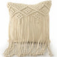 Against a white background, the Beige White Macrame Cushion with Fringes, a square accent pillow you can buy online at Sukham Home, a sustainable furniture, kitchen & dining and home decor store in Kolkata, India