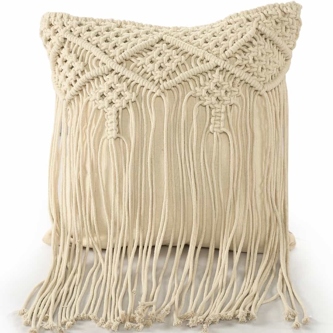 Against a white background, the Beige White Macrame Cushion with Fringes, a square accent pillow you can buy online at Sukham Home, a sustainable furniture, kitchen & dining and home decor store in Kolkata, India