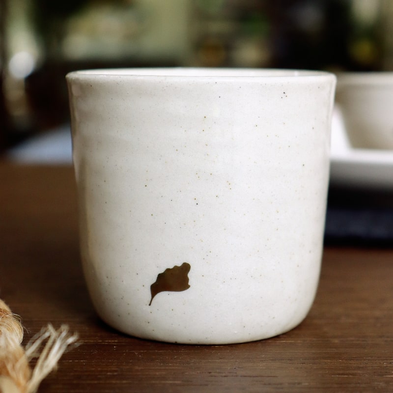 Side view of the Beige Ganga Kulhad, an off-white and 24-karat gold ceramic cup/glass you can buy online at Sukham Home, a sustainable furniture, gardening and home decor store in Kolkata, India