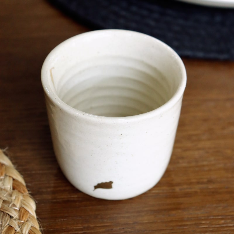 Angled view of the Beige Ganga Kulhad, an off-white and 24-karat gold ceramic cup/glass you can buy online at Sukham Home, a sustainable furniture, gardening and home decor store in Kolkata, India