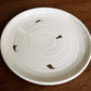 Side tilted view of the Beige Ganga Quarter Plate, an off-white and 24-karat gold ceramic small plate you can buy online at Sukham Home, a sustainable furniture, gardening and home decor store in Kolkata, India