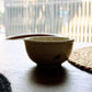 Against the light, silhouette of the Beige Ganga Small Bowl, an off-white and 24-karat gold ceramic small bowl you can buy online at Sukham Home, a sustainable furniture, gardening and home decor store in Kolkata, India