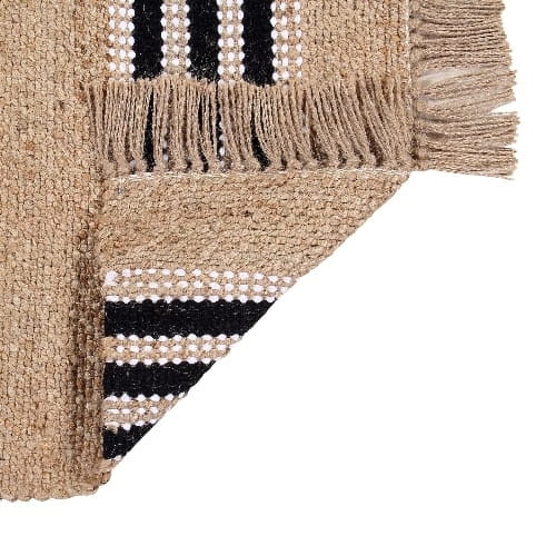 Showcasing both sides of the Handwoven Jute Rug with Black and White Stripes and Tassels, a small rectangle jute and black & white cotton carpet you can buy online at Sukham Home, a sustainable furniture, kitchen & dining and home decor store in Kolkata, India