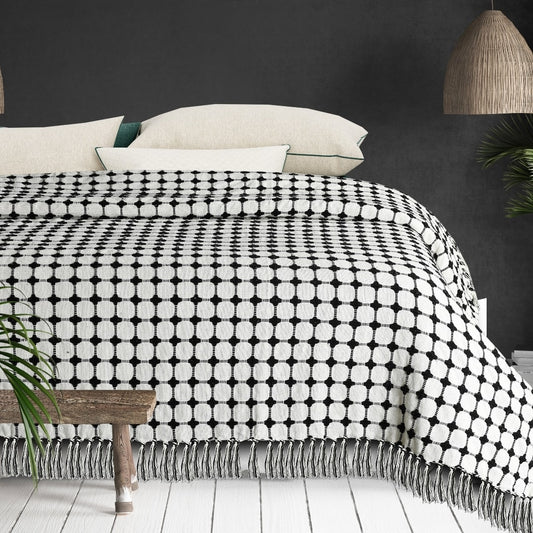 Placed on a bed, the Black and White Cotton Bedcover Throw you can buy online at Sukham Home, a sustainable furniture, kitchen & dining and home decor store in Kolkata, India