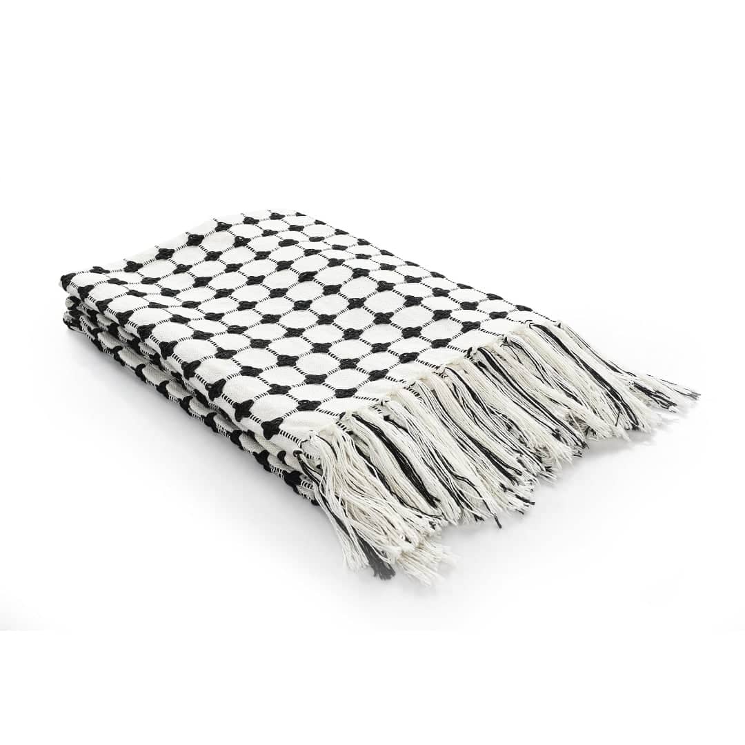 Against a white background, the folded Black and White Cotton Bedcover Throw you can buy online at Sukham Home, a sustainable furniture, kitchen & dining and home decor store in Kolkata, India