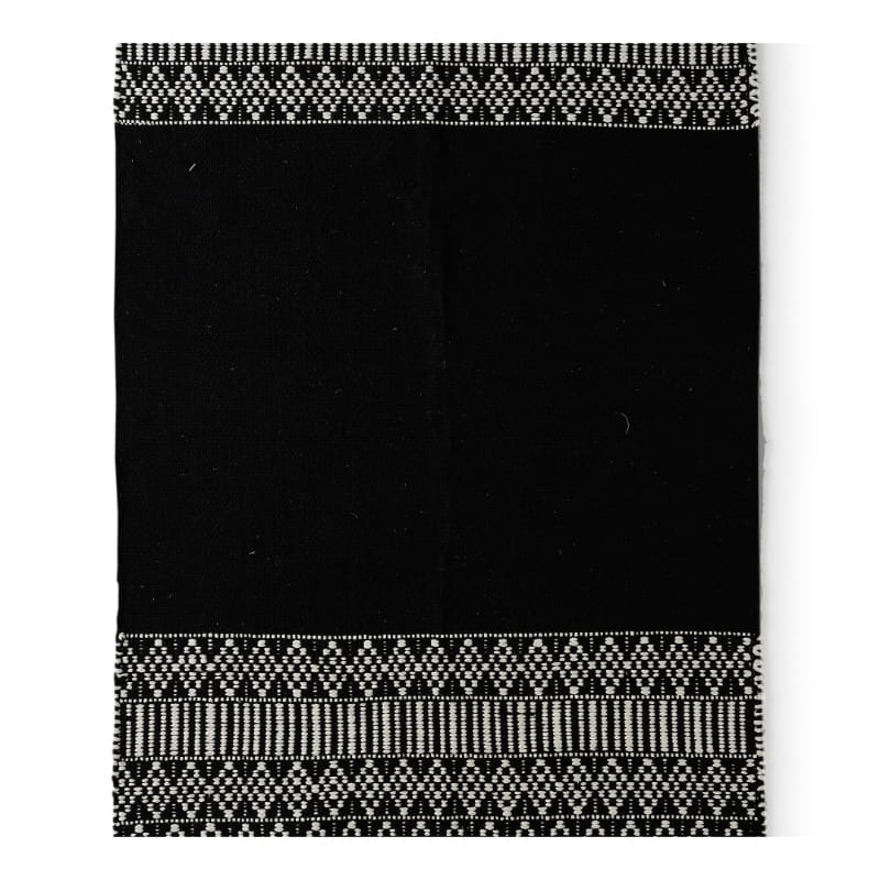 Against a white background, the Woven Black and White Rug, a rectangle cotton carpet in black & white you can buy online at Sukham Home, a sustainable furniture, kitchen & dining and home decor store in Kolkata, India