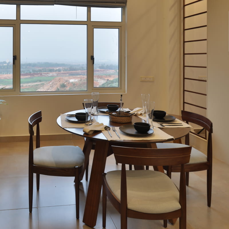 Whole dining set of the Walnut Natural Bow, a solid wood chair with a padded cushion seat you can buy online at Sukham Home, a sustainable furniture and home decor store in Kolkata, India