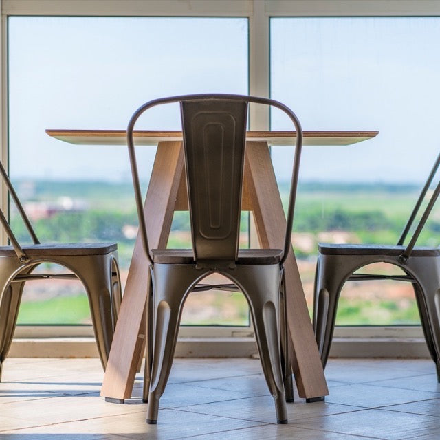 Used in a cafe, the square Como, a wooden square table you can buy online at Sukham Home, a sustainable furniture, kitchen & dining and home decor store in Kolkata, India