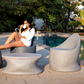 By the swimming pool, Olivia Table, a stone finish plastic outdoor furniture table you can buy online at Sukham Home, a sustainable furniture, kitchen & dining and home decor store in Kolkata, India