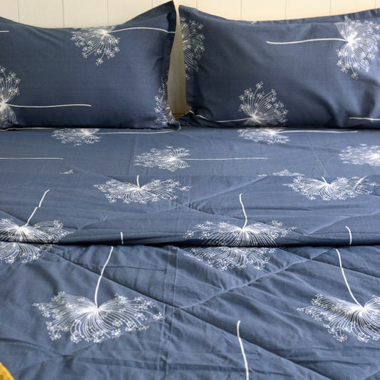 Close up of the design and texture of the Dandelion Blue-Grey Comforter, a blue and beige printed king size cotton quilt you can buy online at Sukham Home, a sustainable furniture, gardening and home decor store in Kolkata, India