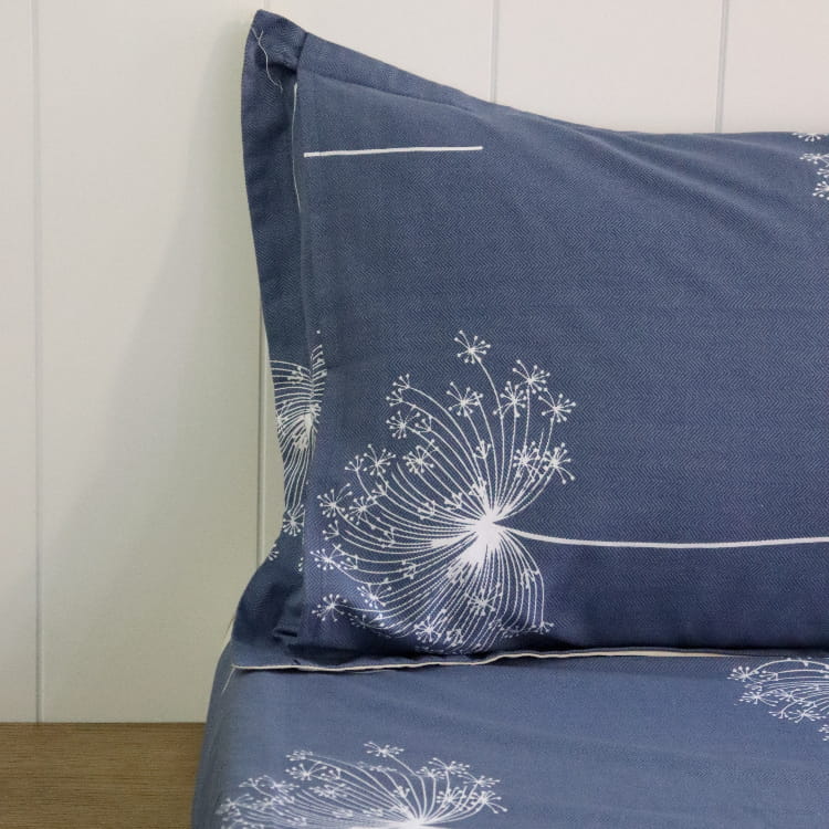 Close up of one pillowcase and sheet of the Dandelion Blue-Grey Printed Bedsheet, a blue and beige king size cotton bedsheet you can buy online at Sukham Home, a sustainable furniture, gardening and home decor store in Kolkata, India