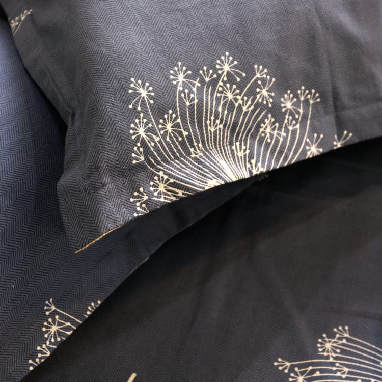 Close up of the blue side of the pillowcases of the Dandelion Blue-Grey Printed Bedsheet, a blue and beige king size cotton bedsheet you can buy online at Sukham Home, a sustainable furniture, gardening and home decor store in Kolkata, India