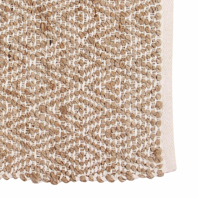 Close up of the weaving pattern of the Handwoven Jute Rug with Diamond Design Weaves, a small rectangle jute and white cotton carpet you can buy online at Sukham Home, a sustainable furniture, kitchen & dining and home decor store in Kolkata, India