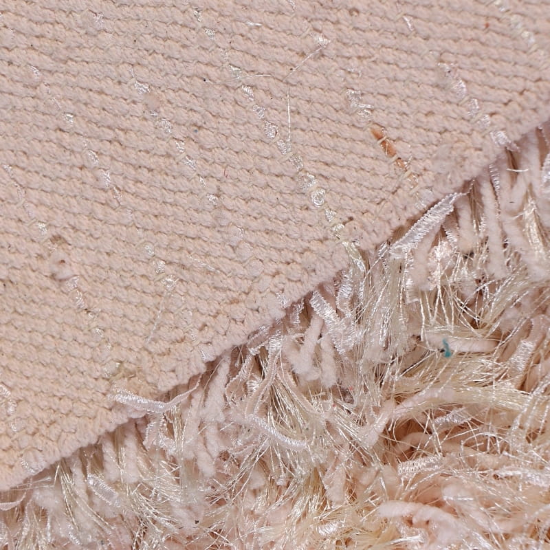 The bottom side of the Dori Shag Rug, a rectangle shaggy cotton carpet in pale pink you can buy online at Sukham Home, a sustainable furniture, kitchen & dining and home decor store in Kolkata, India