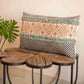 Distant front view of the Elysian Fringed Cushion, a rectangle handpainted and tufted accent pillow you can buy online at Sukham Home, a sustainable furniture, kitchen & dining and home decor store in Kolkata, India