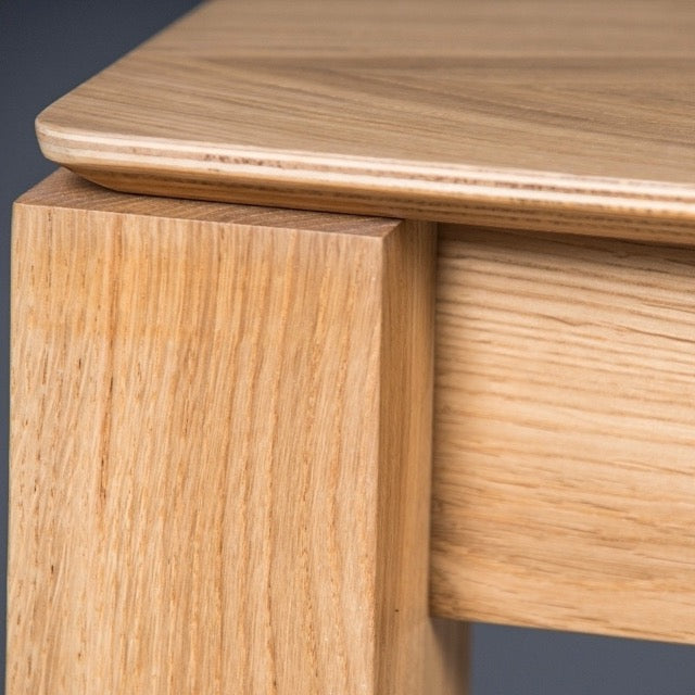 Close up of the joint of the Enlace, a wooden rectangle dining table you can buy online at Sukham Home, a sustainable furniture, kitchen & dining and home decor store in Kolkata, India