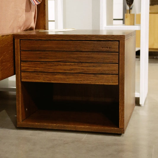 Side view of the Walnut Natural Facile, a wooden bedside table with a slatted drawer and cubby storage you can buy online at Sukham Home, a sustainable furniture, kitchen & dining and home decor store in Kolkata, India