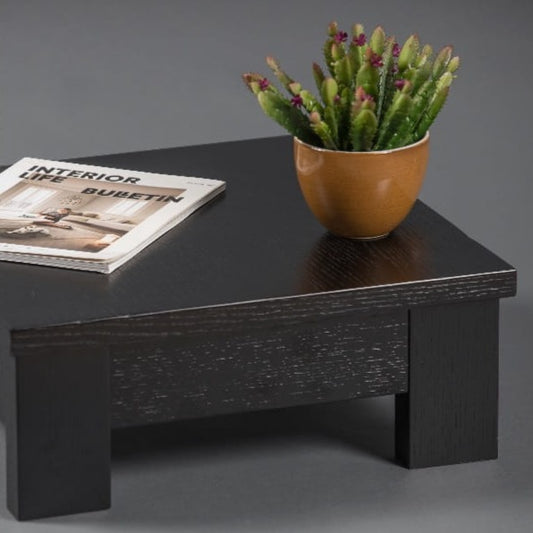 Against a grey background, with plants and books arranged on top, the Fillet Centre Table, a wooden coffee and centre table inspired by Indian Bajot Table/Chowki you can buy online at Sukham Home, a sustainable furniture, kitchen & dining and home decor store in Kolkata, India