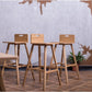 From a distance, three Oak Natural Flamingo Bar Stool, a solid wood high bar chair you can buy online at Sukham Home, a sustainable furniture and home decor store in Kolkata, India