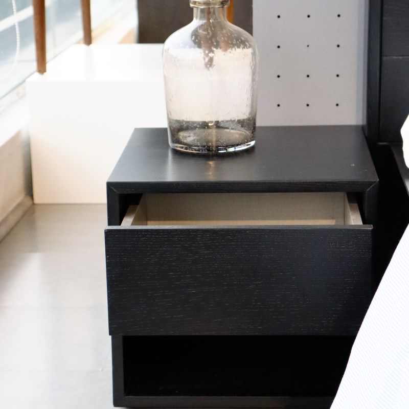 With the drawer open, the Ash Charcoal Fred, a wooden bedside table with a drawer and cubby storage you can buy online at Sukham Home, a sustainable furniture, kitchen & dining and home decor store in Kolkata, India