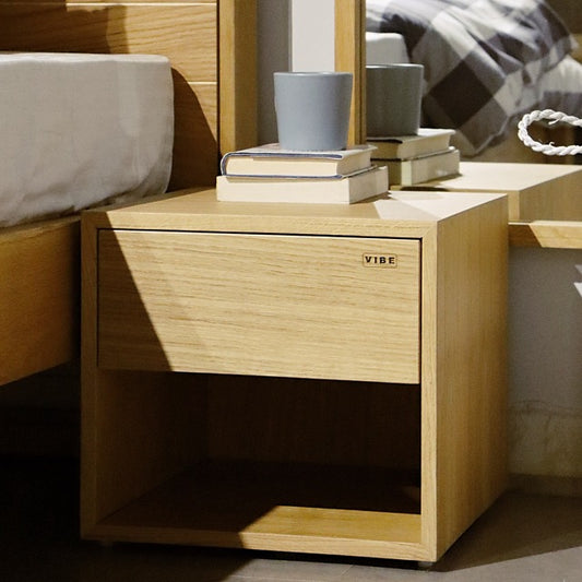 Side view of the Oak Natural Fred, a wooden bedside table with a drawer and cubby storage you can buy online at Sukham Home, a sustainable furniture, kitchen & dining and home decor store in Kolkata, India